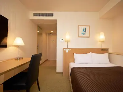 a hotel room with a bed and a desk at The OneFive Tokyo Kameido in Tokyo