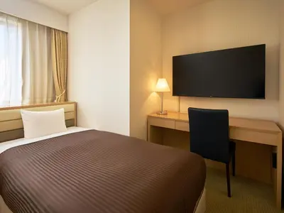 a hotel room with a bed and a desk and a television at The OneFive Tokyo Kameido in Tokyo