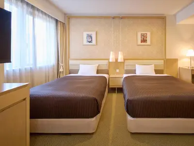 a hotel room with two beds and a television at The OneFive Tokyo Kameido in Tokyo