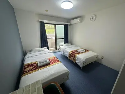 two beds in a room with a window at Aakabane Apart ment 3 Wei hefuyan7190 in Tokyo