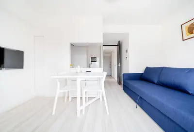 a living room with a blue couch and a white table at Ikebukuro Base in Tokyo