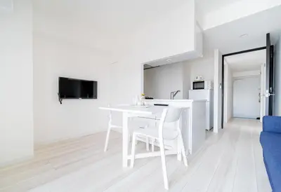 a white kitchen with a white table and chairs at Ikebukuro Base in Tokyo