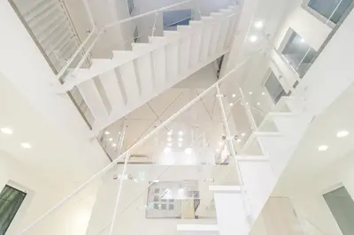a white staircase in a house with white ceilings at UN-Villa in Tokyo