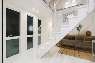 a staircase in a house with white walls and windows at UN-Villa in Tokyo