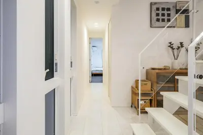 a hallway with white walls and a white stair case at UN-Villa in Tokyo