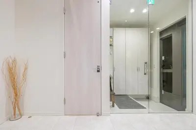 a hallway with white walls and a glass door at UN-Villa in Tokyo