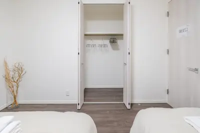 a bedroom with two beds and a door to a closet at UN-Villa in Tokyo