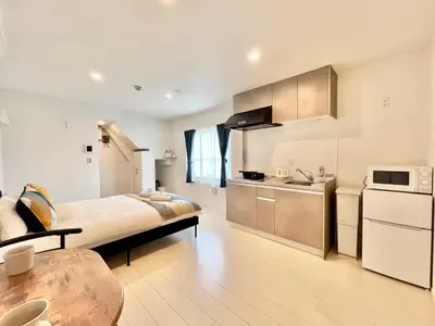 a bedroom with a large bed and a kitchen at 君の家AOTO#Haneda&Narita Access#Free reserved parking in Tokyo