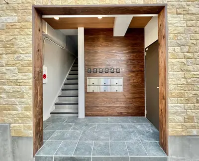a hallway with a wooden front door with stairs at 君の家AOTO#Haneda&Narita Access#Free reserved parking in Tokyo