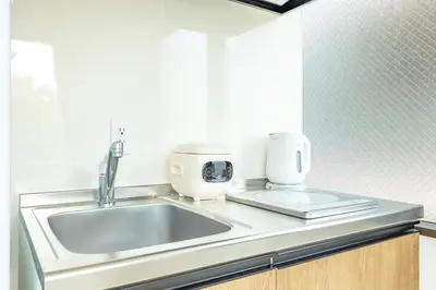 a kitchen counter with a sink and a coffee maker at Shinjuku Waseda Haruno B&B in Tokyo