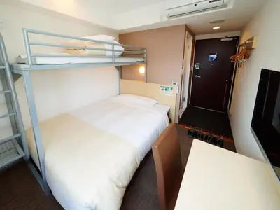 a small room with two bunk beds and a table at Super Hotel Akihabara Suehirocho in Tokyo