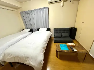 a room with two beds and a table with a chair at S,F, Heights - Vacation STAY 18008 in Tokyo