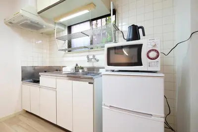 a kitchen with a microwave on top of a refrigerator at Heisei Mansion - Vacation STAY 18017 in Tokyo