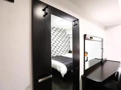 a mirror in a room with a bed and a bedroom at APA Hotel Akabane Iwabuchi Ekimae in Tokyo