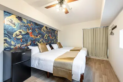 a bedroom with two beds and a painting on the wall at \u6771\u65b0\u5bbf 1112 in Tokyo