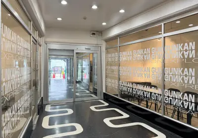 a hallway of a building with a door and signs on the wall at \u6771\u65b0\u5bbf 1110 in Tokyo