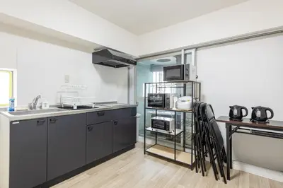 a kitchen with black cabinets and a counter top at \u6771\u65b0\u5bbf 1110 in Tokyo