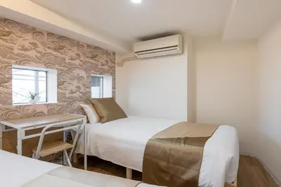 a small bedroom with two beds and a window at \u6771\u65b0\u5bbf 1110 in Tokyo