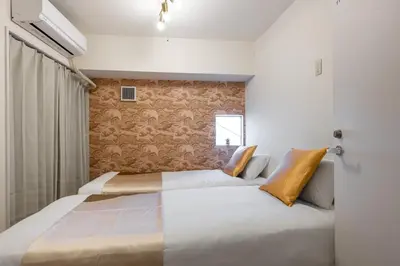 a bedroom with two beds and a window at \u6771\u65b0\u5bbf 1111 in Tokyo
