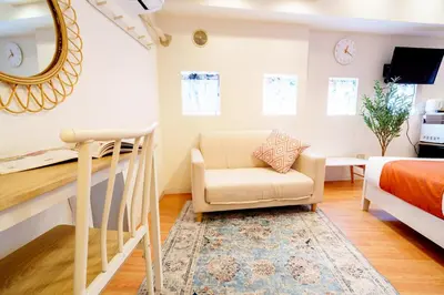 a bedroom with a bed and a chair and a mirror at Higashi-Shinjuku 902 in Tokyo
