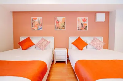 two beds in a room with orange pillows at Higashi-Shinjuku 902 in Tokyo
