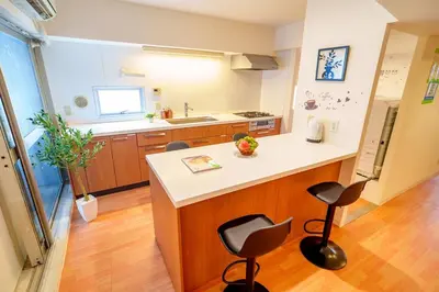 a kitchen with a counter and two bar stools at Higashi-Shinjuku 906 in Tokyo