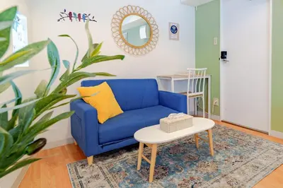 a blue couch in a living room with a table at Higashi-Shinjuku 906 in Tokyo