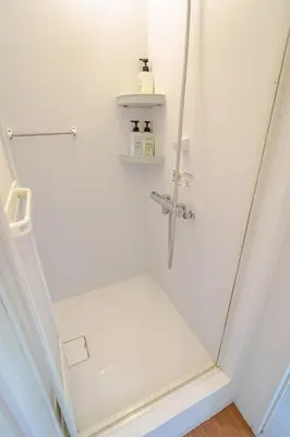 a white bathroom with a shower in a room at Higashi-Shinjuku 905 in Tokyo