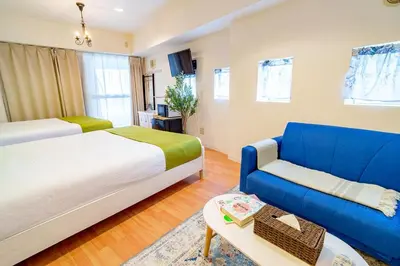 a bedroom with a bed and a blue couch at Higashi-Shinjuku 905 in Tokyo