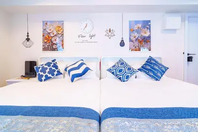 a bed with blue and white pillows on it at Higashi-Shinjuku 903 in Tokyo