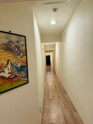 a hallway with a painting hanging on a wall at Higashi-Shinjuku 14F in Tokyo