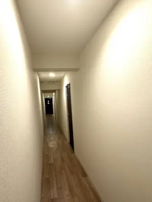 an empty hallway with a long corridor with wood floors at Higashi-Shinjuku 14F in Tokyo