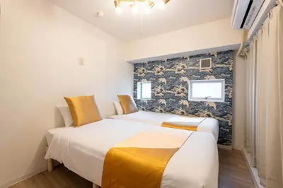 two beds in a room with a wall at \u6771\u65b0\u5bbf 1102 in Tokyo