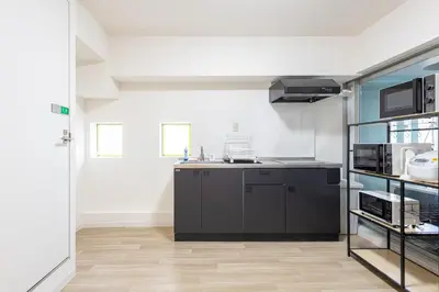 a kitchen with black cabinets and a counter top at \u6771\u65b0\u5bbf 1102 in Tokyo