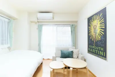 a white room with two tables and a couch at Alba cerezo by Tranova in Tokyo
