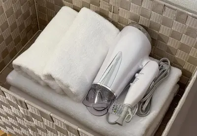 a set of towels and a hair dryer on a shelf at \u6771\u65b0\u5bbf 1105 in Tokyo