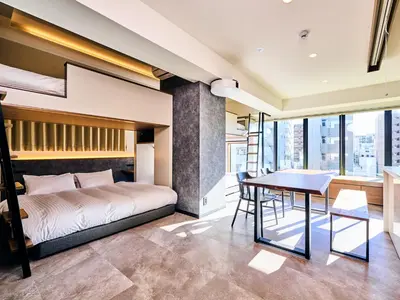 a bedroom with a bed and a dining room with a table at HOTEL ALL IN TOKYO Asakusabashi in Tokyo