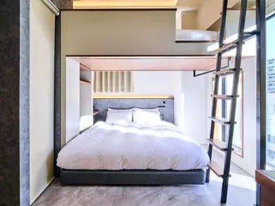 a bedroom with a bunk bed and a ladder at HOTEL ALL IN TOKYO Asakusabashi in Tokyo