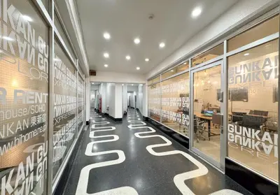 a hallway of a store with tables and windows at \u6771\u65b0\u5bbf 1106 in Tokyo