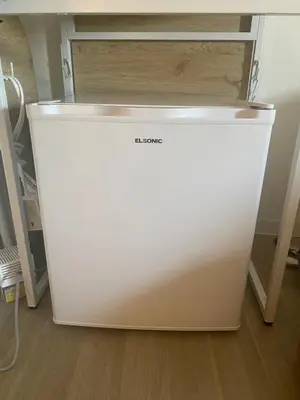 a white refrigerator sitting on the floor in a room at \u6771\u65b0\u5bbf 1109 in Tokyo