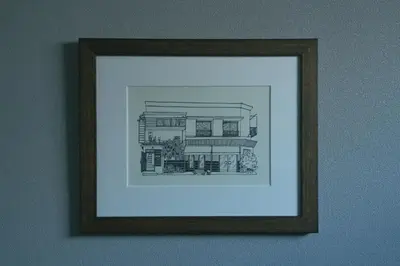 a framed drawing of a house on a wall at innnn higashinagasaki in Tokyo