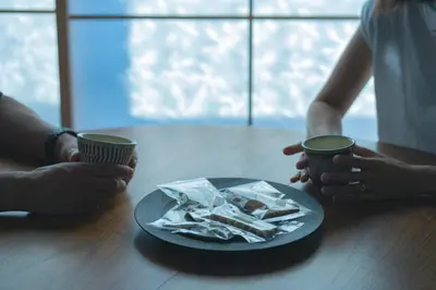 two people sitting at a table with a plate of food at innnn higashinagasaki in Tokyo