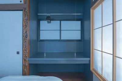 a bedroom with a window and a blue wall at innnn higashinagasaki in Tokyo