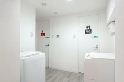a white bathroom with two sinks and a washing machine at \u6771\u65b0\u5bbf 1107 in Tokyo