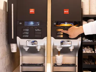 a person is pointing at a coffee machine at SUPER HOTEL Ikebukuro West Natural Hot Spring in Tokyo