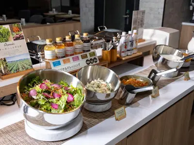 a buffet with bowls of food on a counter at SUPER HOTEL Ikebukuro West Natural Hot Spring in Tokyo