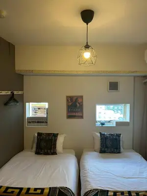 a room with two beds and a light fixture at Higashi-Shinjuku 1002 in Tokyo