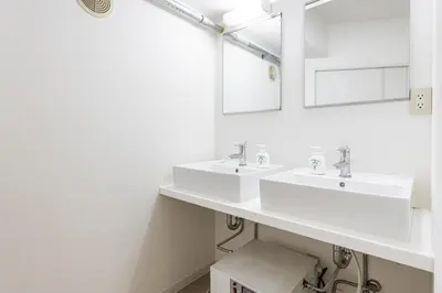 a white bathroom with two sinks and a mirror at Higashi-Shinjuku 1002 in Tokyo