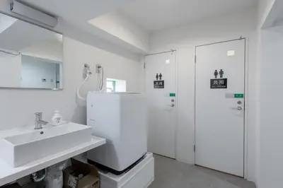 a white bathroom with a sink and a shower at Higashi-Shinujuku 1008 in Tokyo