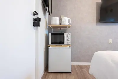 a small kitchen with a microwave on top of a refrigerator at Higashi-Shinujuku 1008 in Tokyo